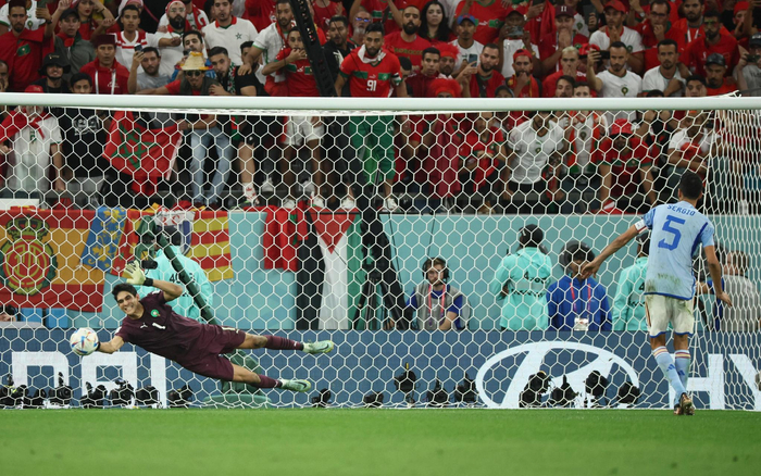 摩洛哥守门员布努（左）在点球大战中扑出西班牙老将布斯克茨的射门。  图/新华社
