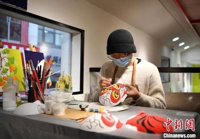 图为12月9日，石家庄市裕华区一家文创非遗体验馆，工作人员绘制戏曲人物脸谱。　翟羽佳 摄