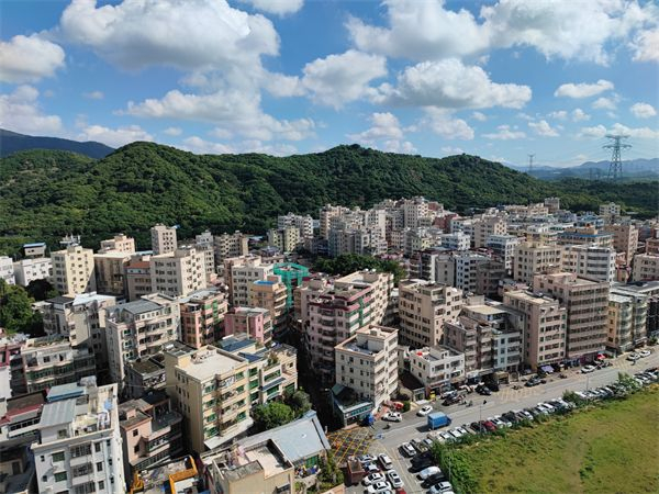深圳白芒村中客家民居被村民自建楼房包围，村前马路原为岩口公路。 记者乔凯摄