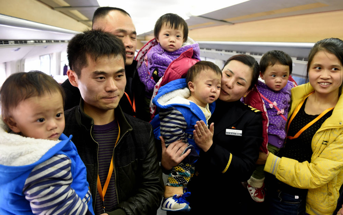 　　↑ 2015年2月11日，四胞胎在G9242列车上与列车工作人员合影留念。