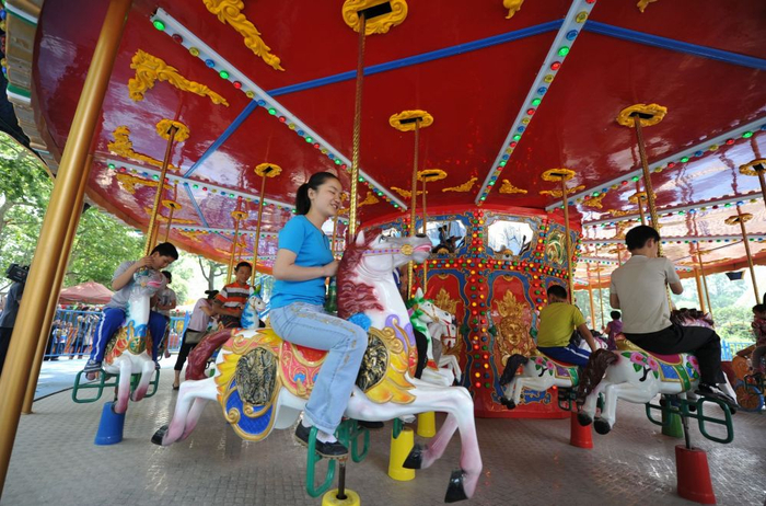 　　↑王香君（前）和她的小伙伴在合肥市逍遥津公园第一次乘坐旋转木马（2010年5月31日摄）。