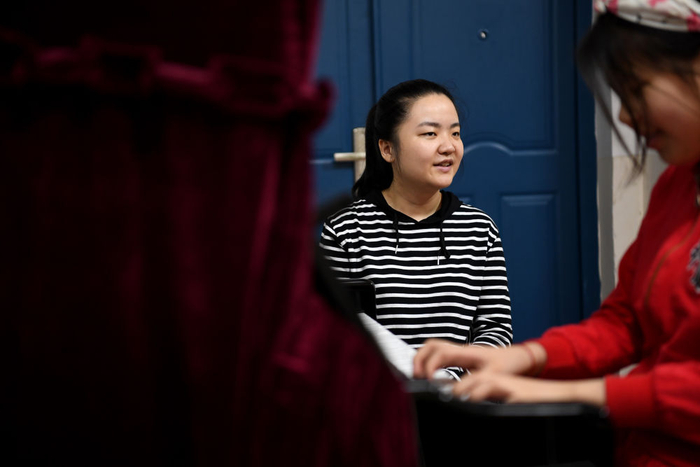 　　↑ 2020年6月18日，王香君在合肥特殊教育中心教视障儿童练习钢琴。