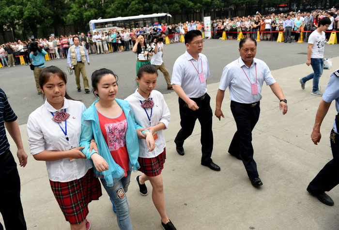 　　↑ 2015年6月7日，王香君（左二）在安徽省合肥世界外国语学校考点志愿者及工作人员带领下进入考场。