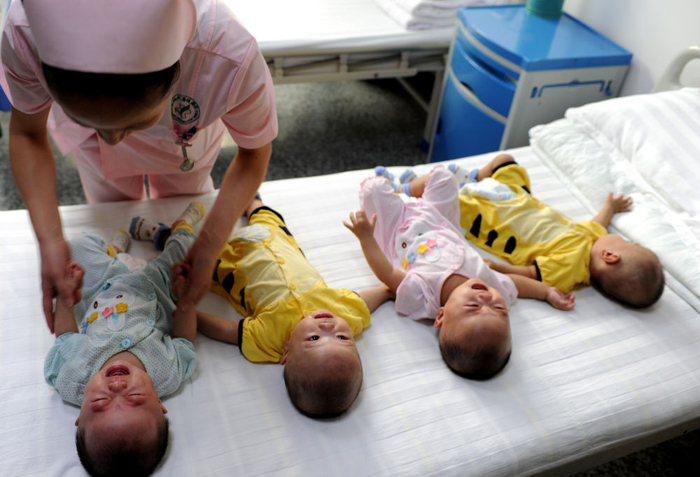 　　↑ 2014年7月18日，在合肥一家医院的病房里，护士在查看四胞胎的身体状况。