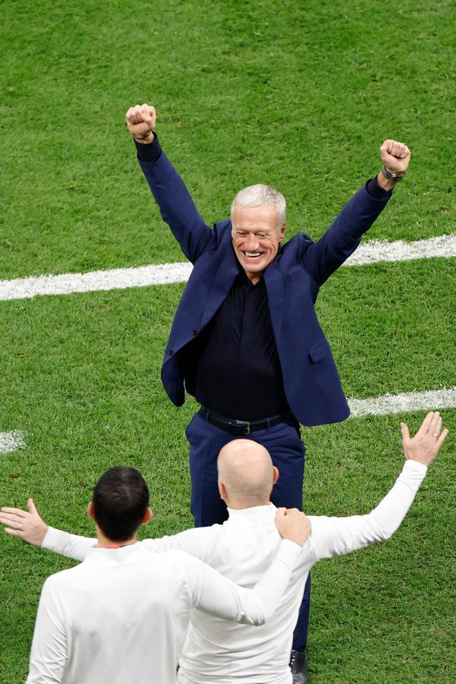 12月14日，法国队主教练德尚（上）在比赛后与教练组成员庆祝胜利。新华社记者 王丽莉 摄