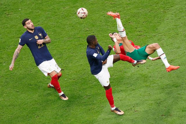 12月14日，摩洛哥队球员亚米克（右）在比赛中倒钩射门。新华社记者 王丽莉 摄