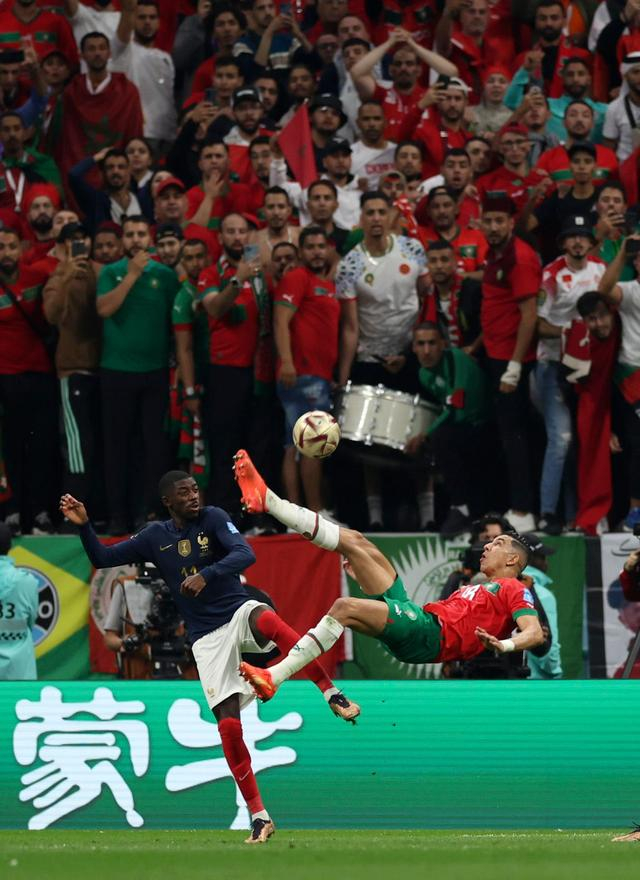 12月14日，摩洛哥队球员亚米克（前右）在比赛中倒钩射门。新华社记者 潘昱龙 摄