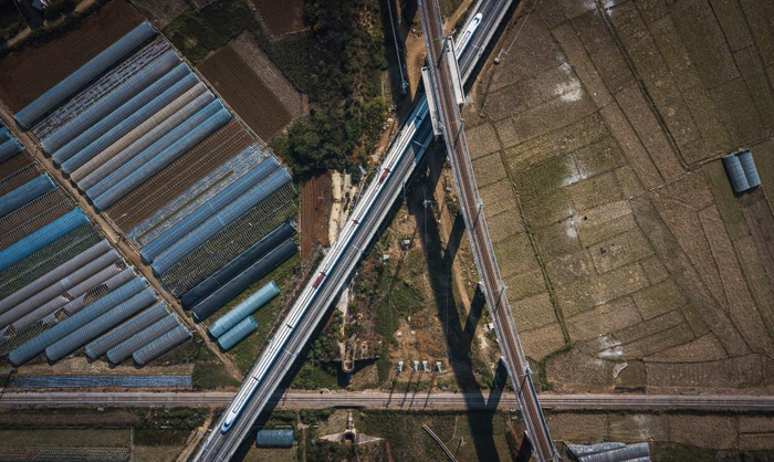 　　12月16日，列车行驶在与玉河铁路（上）、滇越铁路（底层）相互交叉的弥蒙高铁线（中）（无人机照片）。新华社记者 王冠森 摄