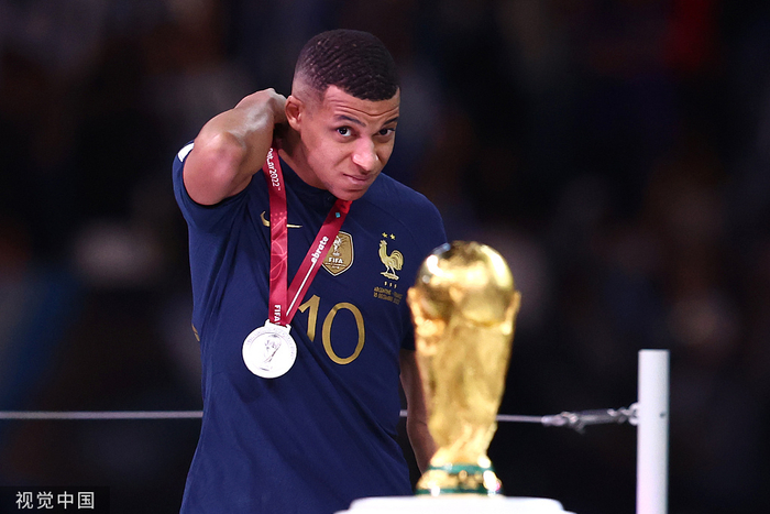 姆巴佩望向大力神杯，摘掉了脖子上的银牌。