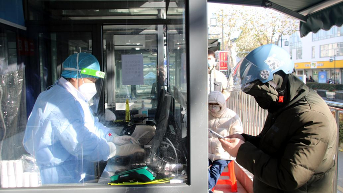 2022年12月18日，苏州，姑苏区双塔街道的居民在十梓街上的“发热诊疗站”就医配药。视觉中国 图