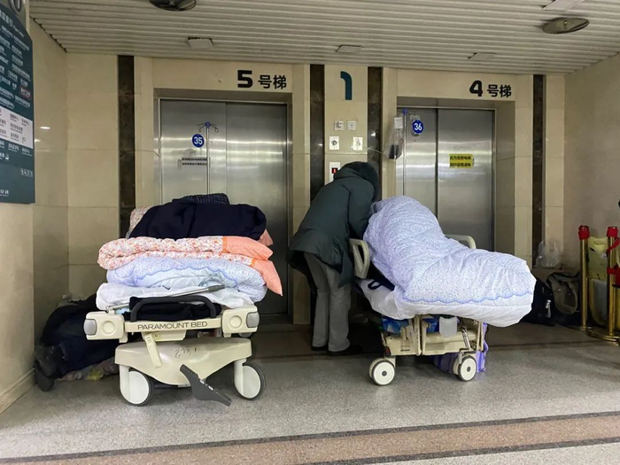 ▲2022年12月15日下午，北京大学第一医院急诊的患者太多，大厅的电梯门口放着两张临时病床。新京报记者 乔迟 摄