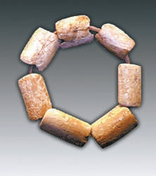 出土的紫游螺项链及骨镯（永定河文化博物馆提供）