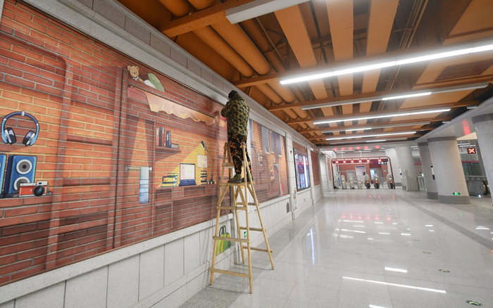 北京地铁昌平线学知园站，工作人员正在站厅层安装壁画。新京报记者 王贵彬 摄