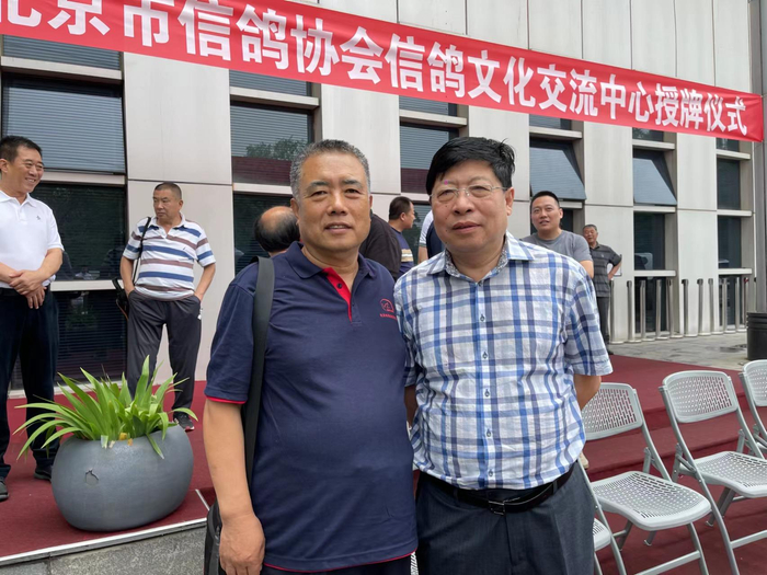 张辉（左）与中国信鸽协会副会长黄剑合影。  受访者供图