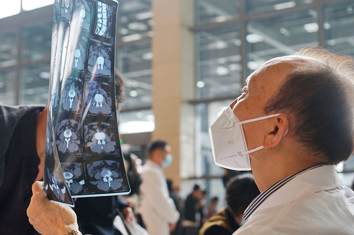 戴N95口罩的医生在为病人诊断。视觉中国 图