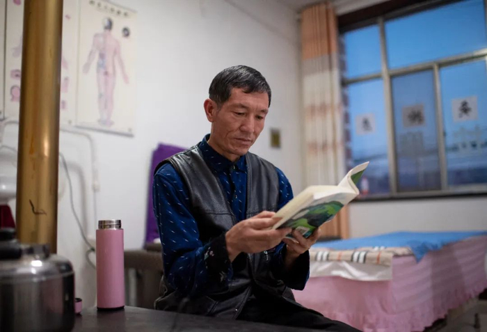 宁夏西吉县农民写作爱好者米志强在自己开的按摩店里看书 冯开华 / 摄