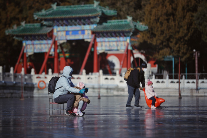 12月29日，北海公园，游客在冰场滑冰车。新京报记者 薛珺 摄