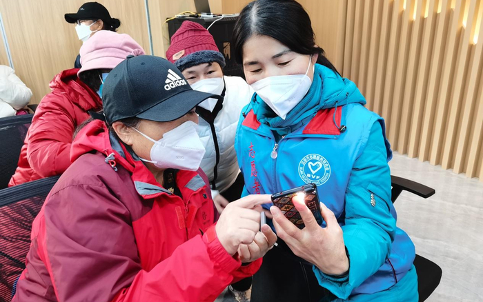 义工胡爱香教老人手机拍照修图。受访者供图