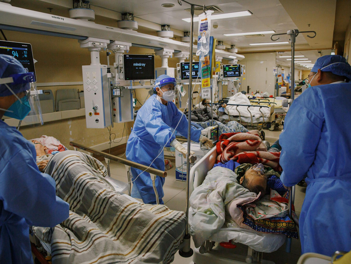 2022年12月27日晚，朝阳医院急诊科抢救室，医务人员腾挪床位接收新的病人。新京报记者 郑新洽 摄