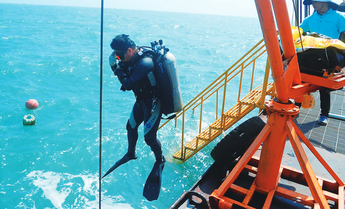 圣杯屿元代沉船遗址点水面，水下考古队员从大型作业船上跳入水中。