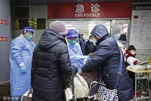 2022年12月26日，上海市同济医院里，医护人员为患者进行急诊预检。图源：视觉中国