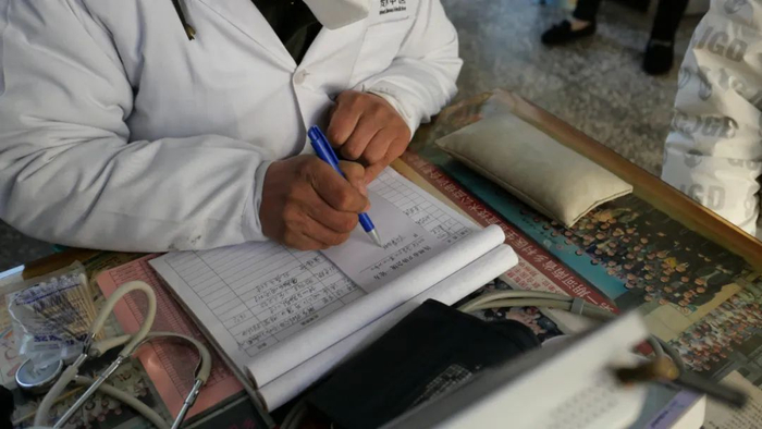 河南汝州某村卫生站的医生在为病人诊治。