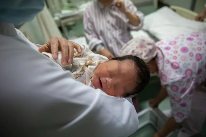 ▲2022年5月7日晚，北京大学首钢医院产科病房，护士抱着一名新生儿。新京报记者 郑新洽 摄