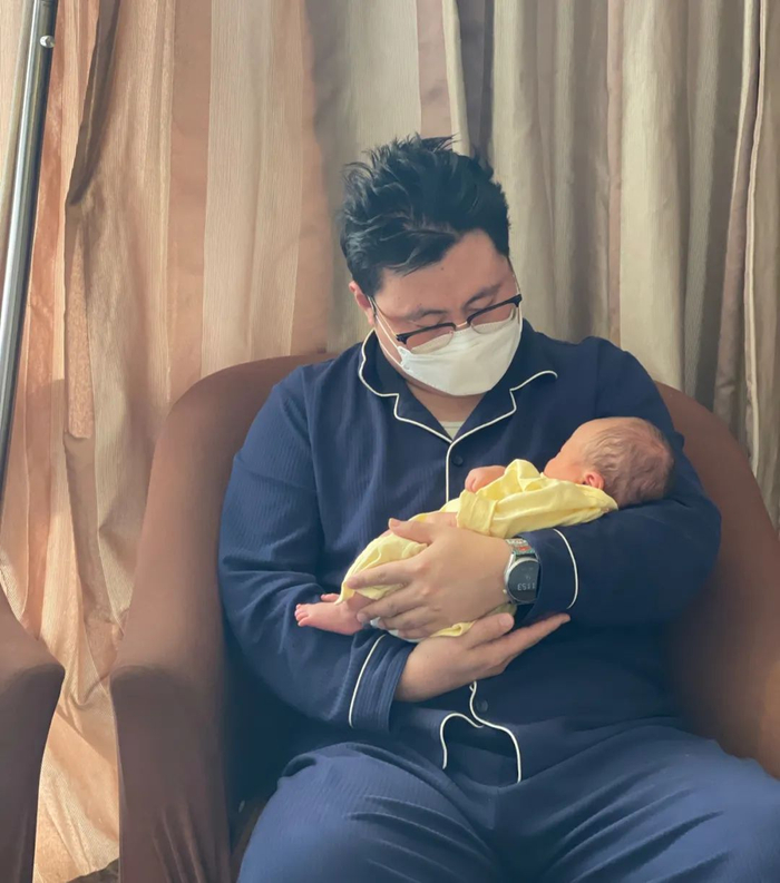 ▲2022年12月底，在月子中心，赵晚安的丈夫抱着他们刚刚康复的孩子。受访者供图