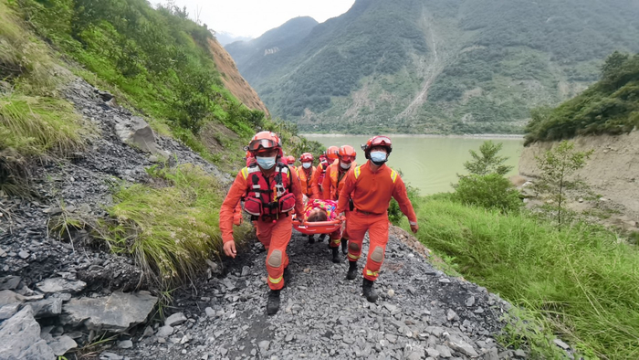 2022年9月6日，泸定地震发生后部分山体垮塌、道路受损，阿坝州森林消防支队消防员徒步转移伤员。 新京报记者 王飞 摄