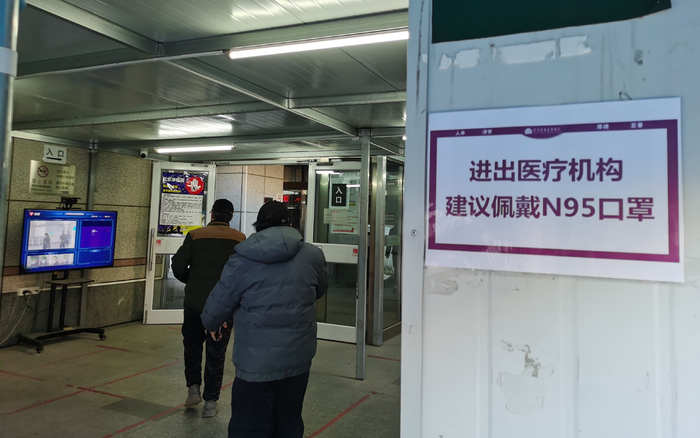 门诊大厅入口张贴提示，建议进入人员佩戴N95口罩。新京报记者 戴轩 摄