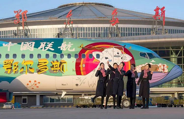 ▲1月7日，中国联合航空一架鄂尔多斯草原文化主题彩绘波音737客机亮相鄂尔多斯机场，机组人员在“鄂尔多斯号”前合影。