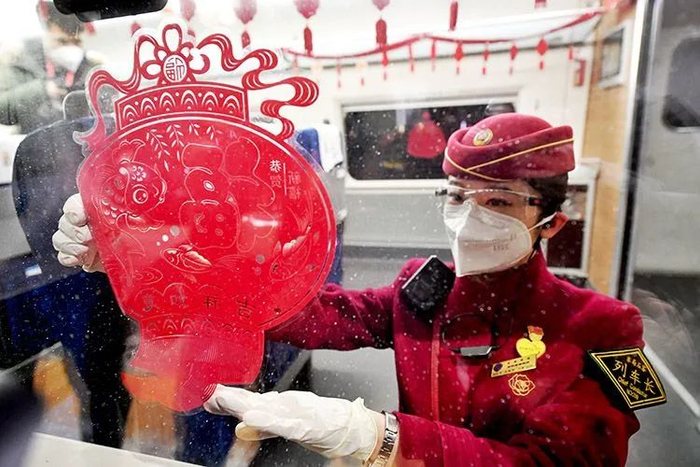 ▲列车长正在整理车窗上的新春剪纸。