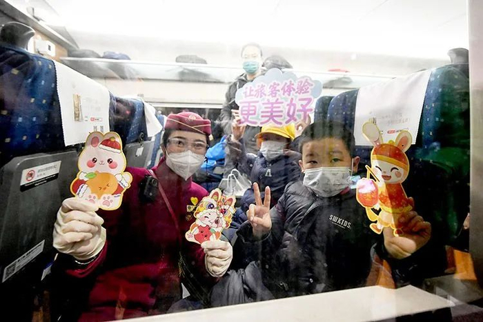 ▲乘务员和小朋友一起展示兔年卡通贴纸。