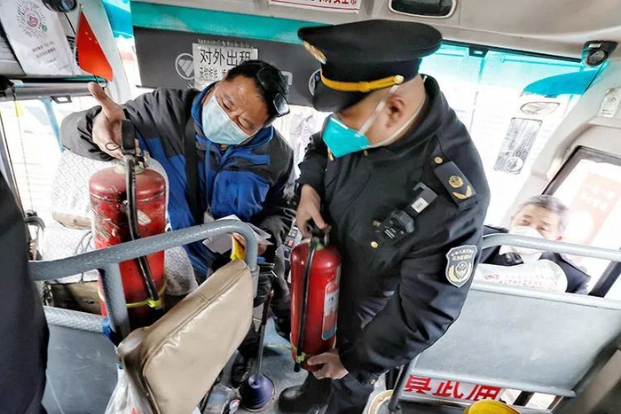 ▲应急管理执法人员正在检查长途客车上的灭火设备。