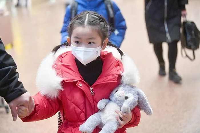 ▲进站大厅里的一位小旅客怀抱毛绒兔玩具。