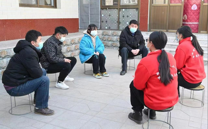 科技小院师生和农户坐在小板凳上沟通农技知识。受访者供图