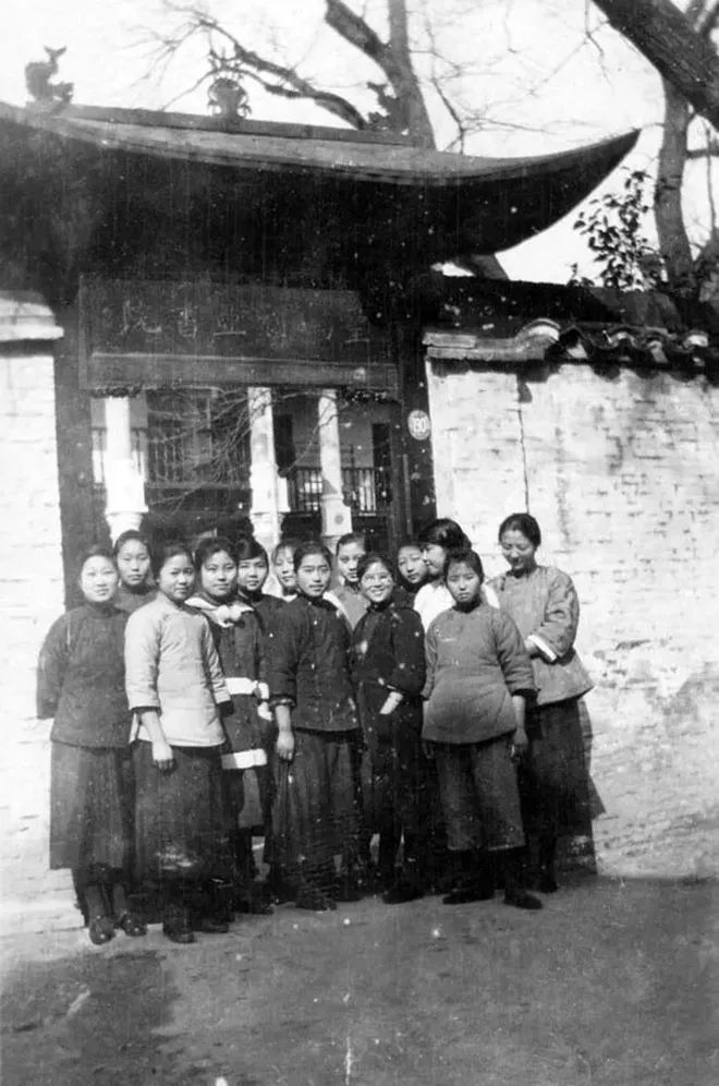 20世纪初的圣玛利亚书院校门，图为部分女生在校门前合影。图中校名匾额清晰可辨