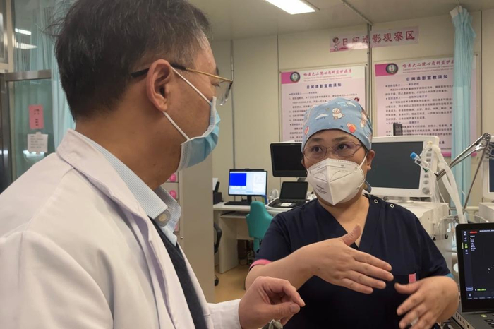 于波（左）和侯静波（右）在交流患者病情，研究救治措施。（新华社记者杨思琪摄）