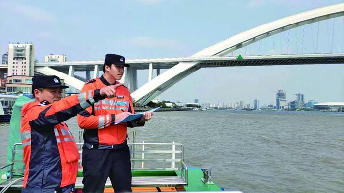 蒋海琦（右）跟同事一起水上巡逻。受访者供图