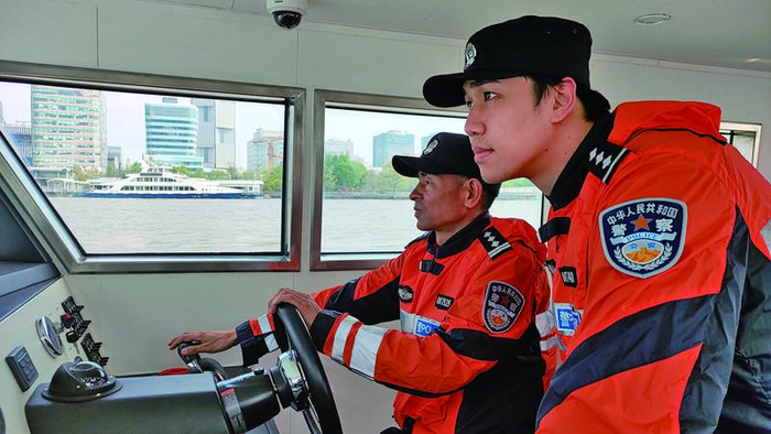 和老警察一起开船的蒋海琦（前），已经能够适应水上的生活。 受访者供图