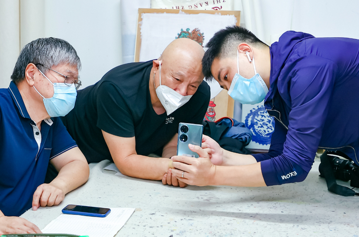 北京开放大学教师向社区老人讲解智能手机用法