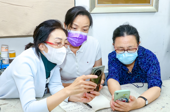 北京开放大学教师向社区老人讲解智能手机用法