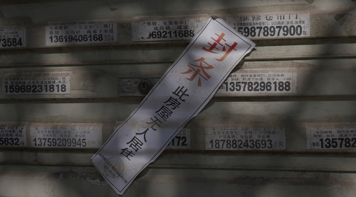 1月6日，云南省德宏州瑞丽市姐告国门社区沿街商铺大多仍关着门，许多卷帘门上依然贴着疫情期间的封条。