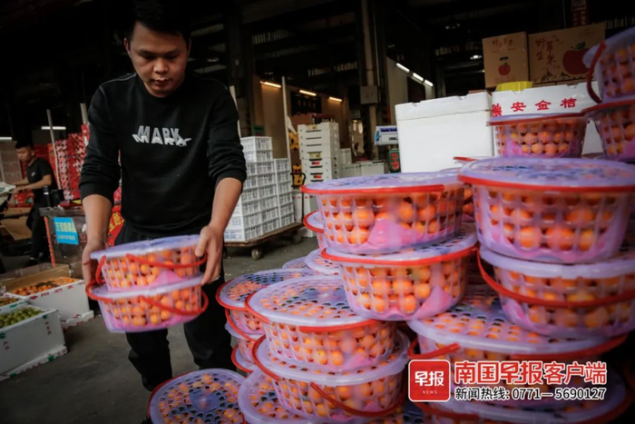 ▲一名果商正在搬运自己的水果。