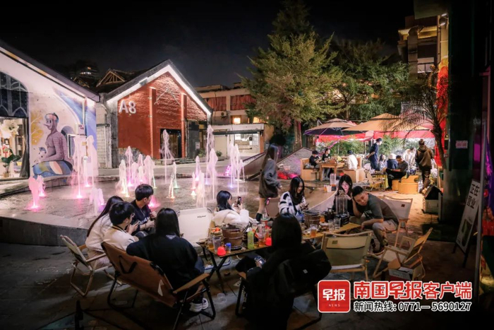 ▲百益上河城，市民在小店外休闲、品尝美食。