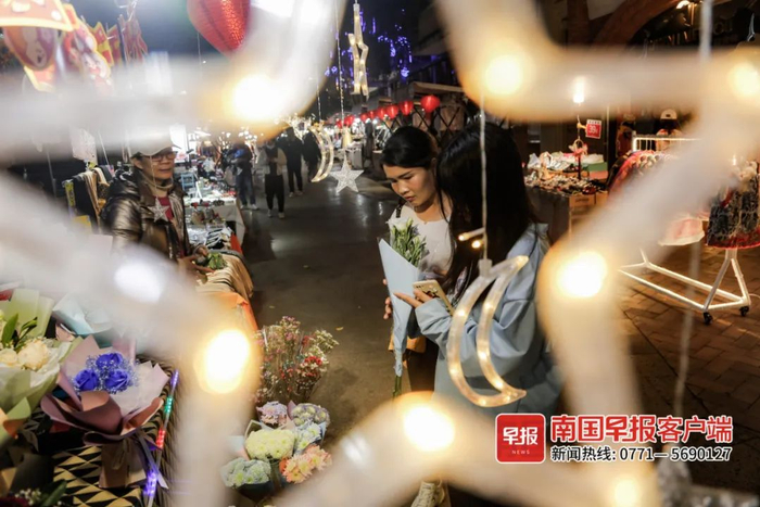 ▲百益上河城，市民在摊点前选购商品。