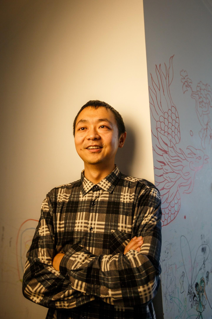 2023年1月7日，北京市房山区，蔡聪在家中。他身后的凤凰是一位朋友到访时画的。新京报记者 王子诚 摄