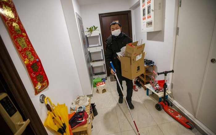 2023年1月7日，蔡聪拿着垃圾，手持盲杖出门。新京报记者 王子诚 摄