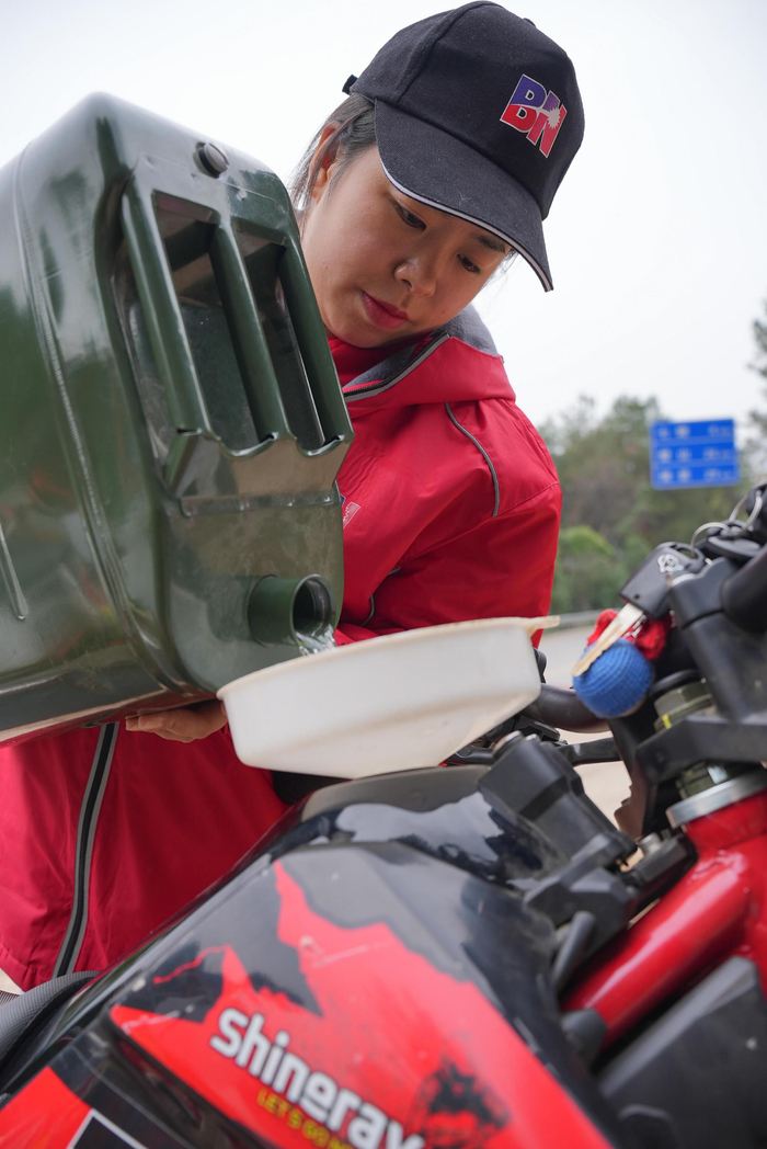 吴朴慧出去骑车时，往车里加水。新京报记者 贺俊怡 摄
