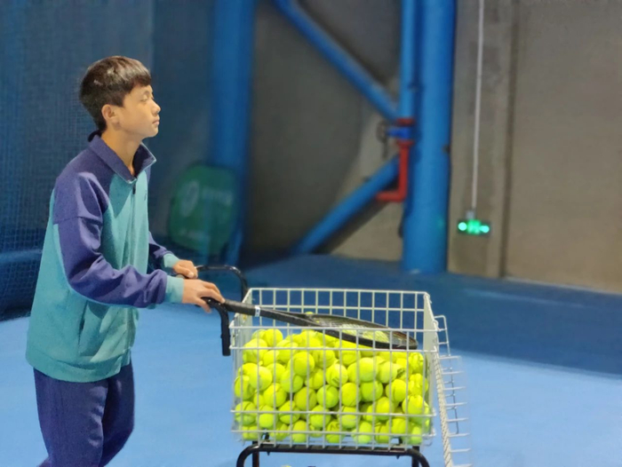 2022年12月30日，训练结束后，王发在场边捡球。新京报记者 汪畅 摄